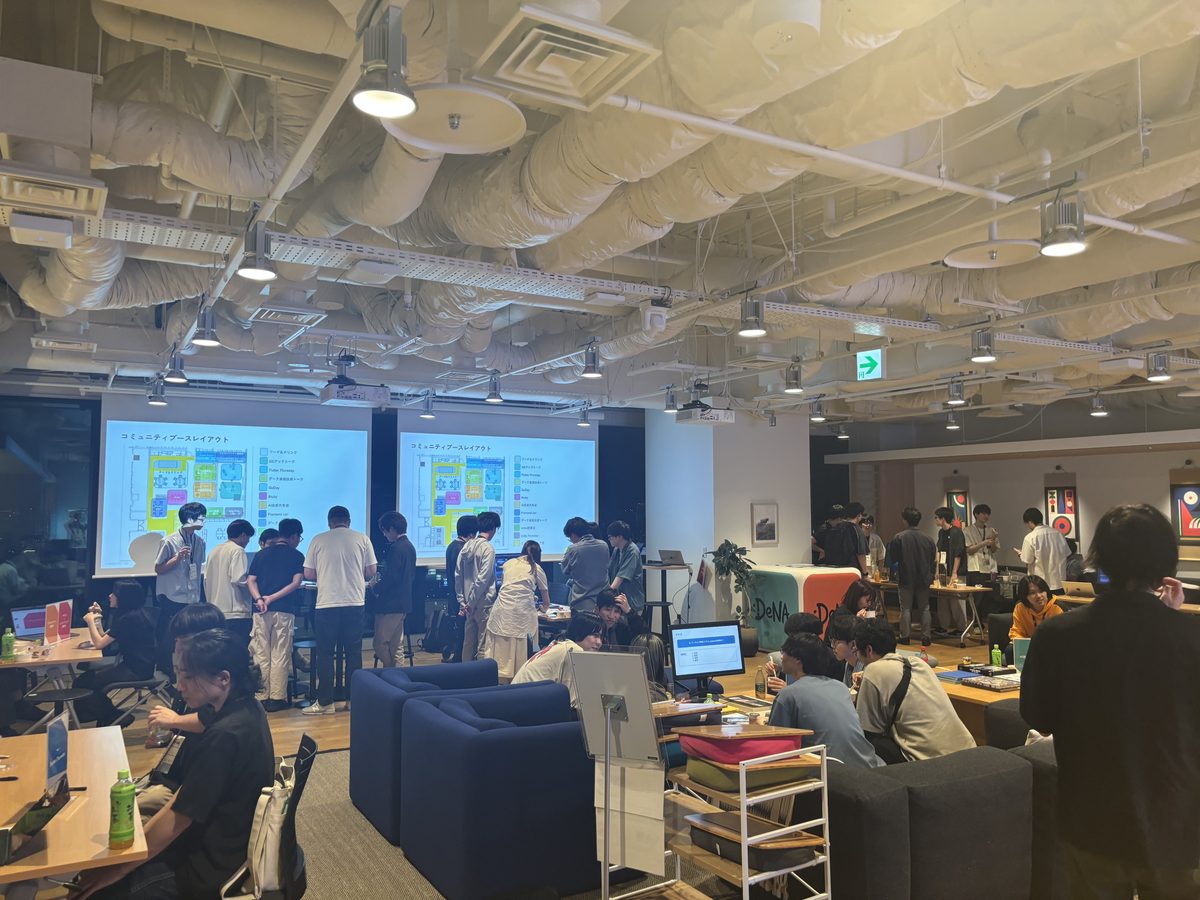 ブースレイアウトを投影したスクリーンと会場全景