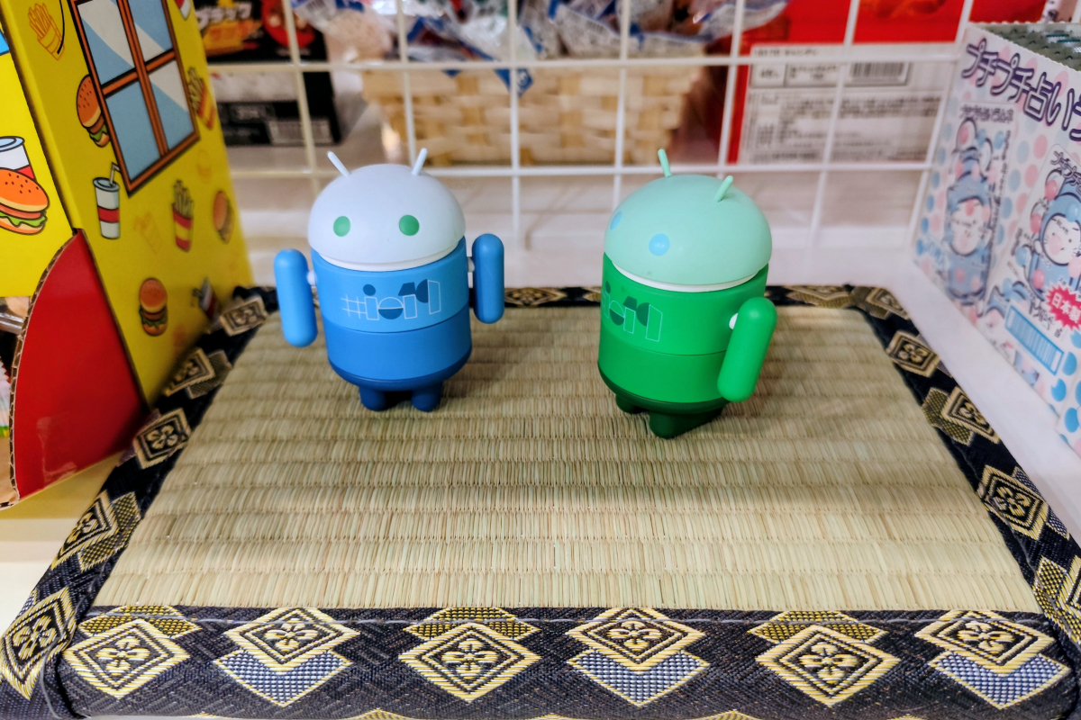 小さな畳の上に並んで置かれた、青色と緑色の2体のAndroidマスコットフィギュアの写真。